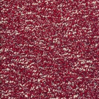 Red bouclé fabric texture with looped yarn, cream fiber speckles, and visible “moroso” textile labeling; upholstery material sample.
